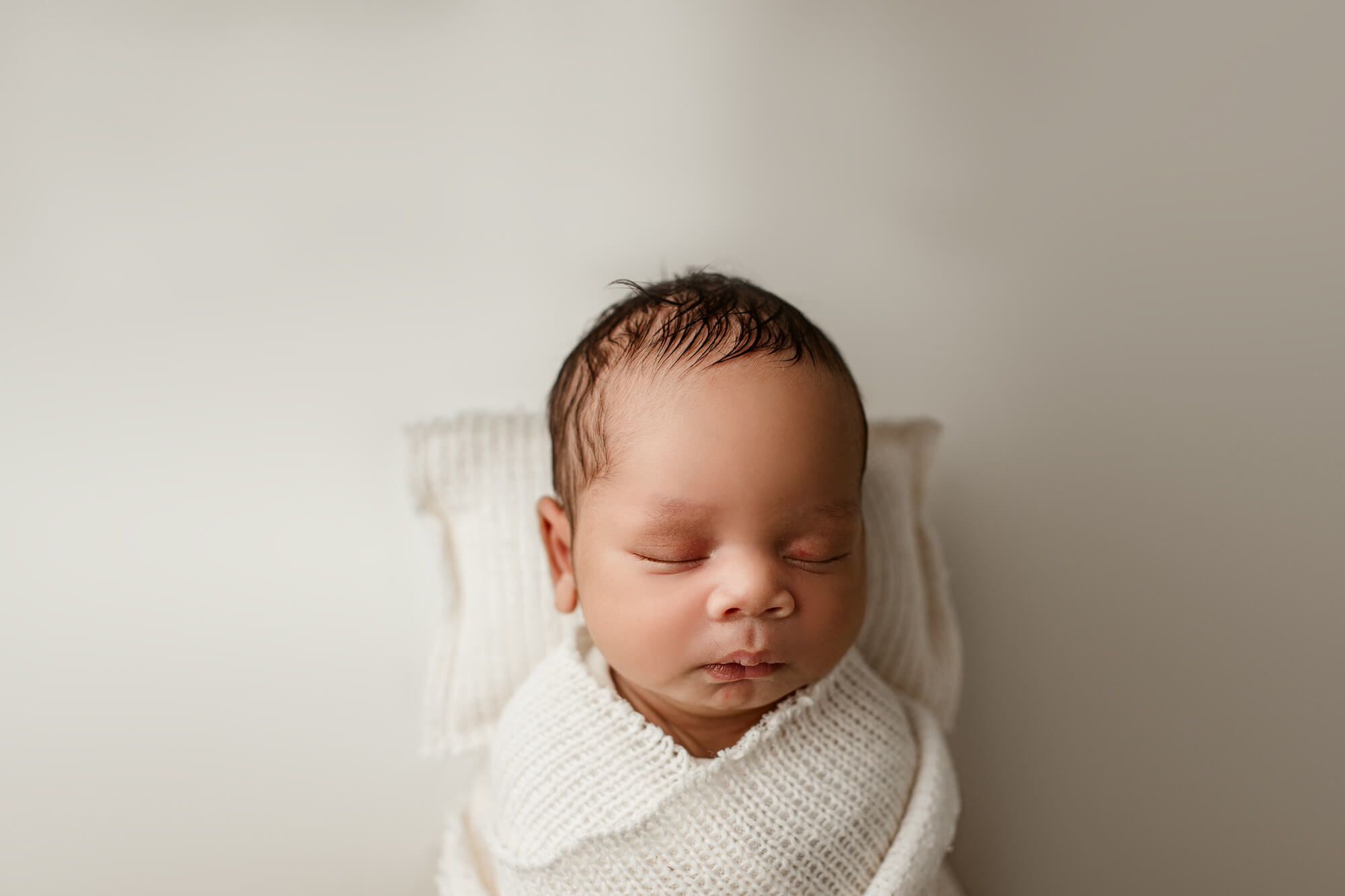 Atlanta baby swaddled sleeping on a pillow during atlanta baby photography session