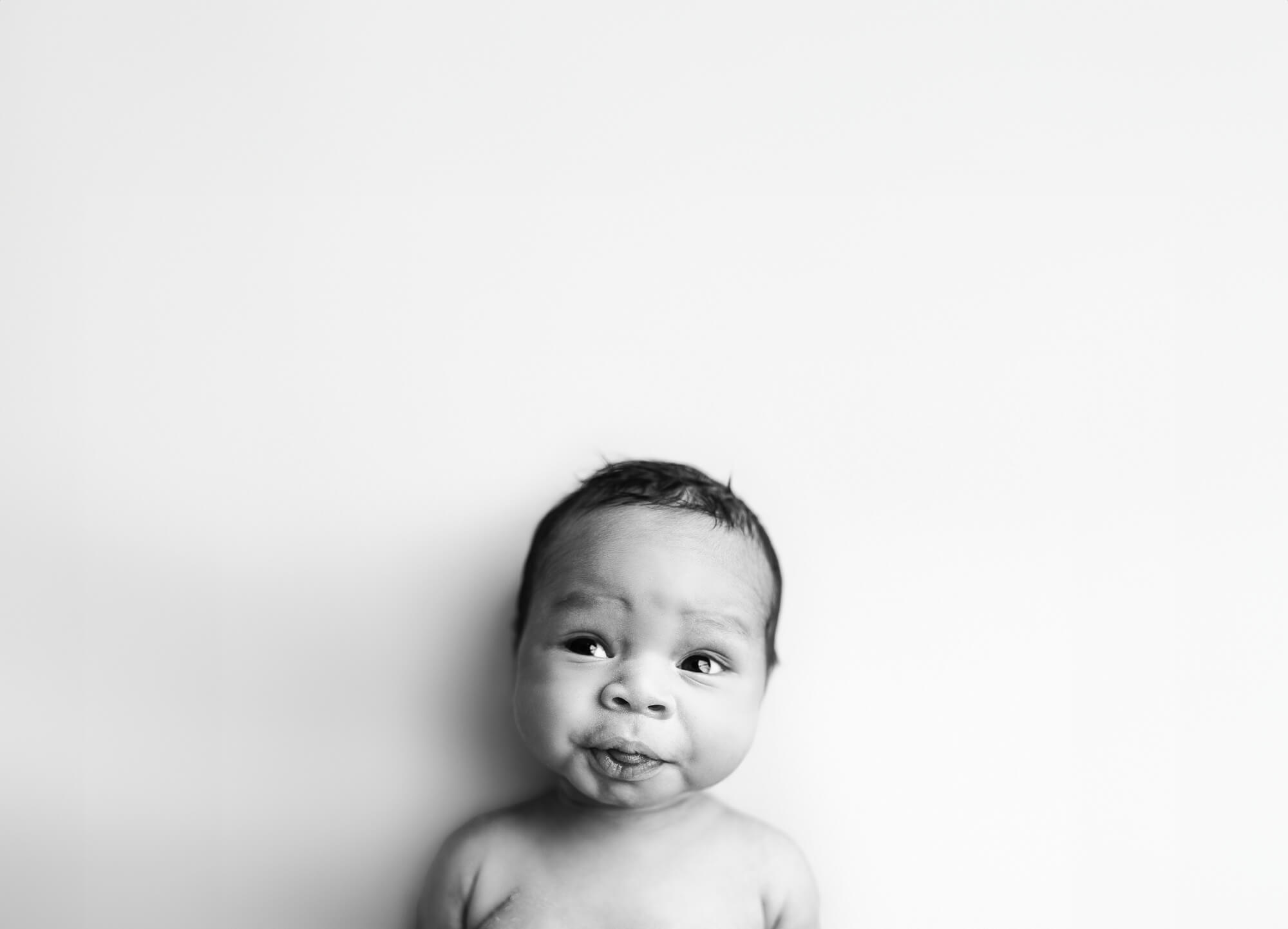 black and white image of newborn smiling during atlanta baby photography shoot