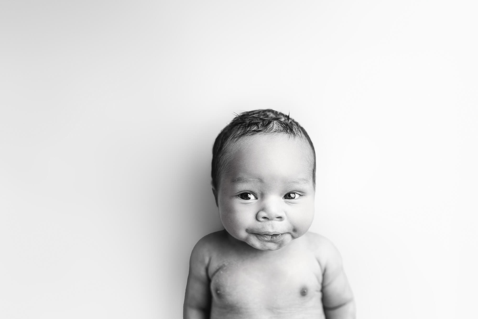 smiling newborn in black and white image