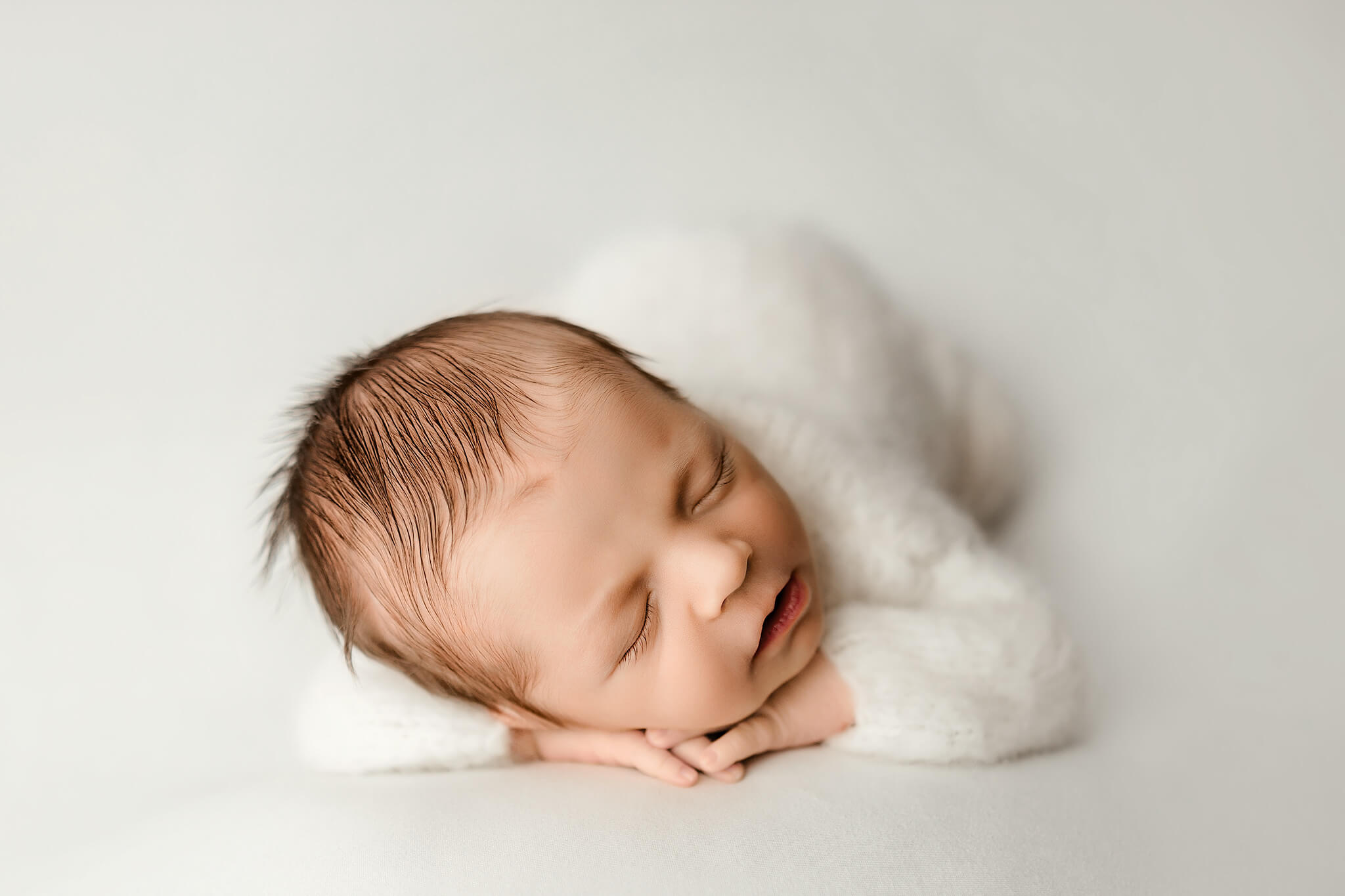 baby posed in all white by woodstock newborn photographer alexes Renea